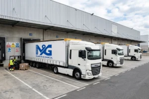Operativa de carga de camiones de la flota propia de Martín & García en muelle logístico industrial.
